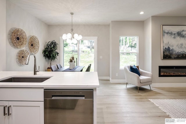5445 S 51st St, Omaha, NE 68117 - kitchen with a sink, dishwasher, decorative light fixtures, a chandelier, and baseboards
