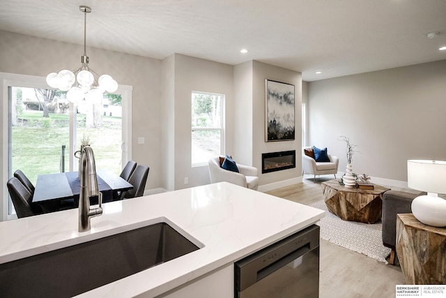 5445 S 51st St, Omaha, NE 68117 - kitchen featuring a sink, dishwashing machine, light wood-style floors, hanging light fixtures, and open floor plan