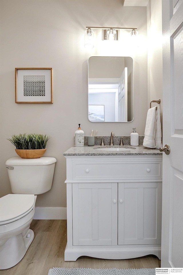 5445 S 51st St, Omaha, NE 68117 - half bath featuring vanity, toilet, wood finished floors, and baseboards
