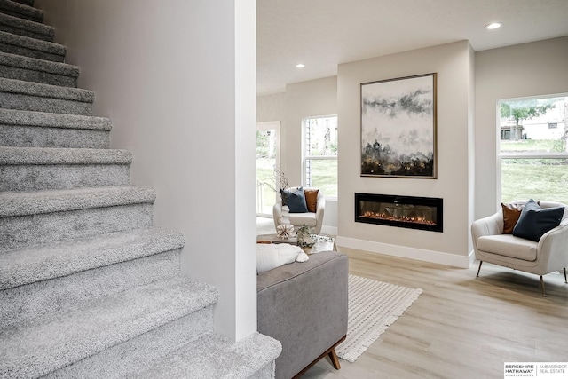 5445 S 51st St, Omaha, NE 68117 - staircase with wood finished floors, healthy amount of natural light, a glass covered fireplace, recessed lighting, and baseboards
