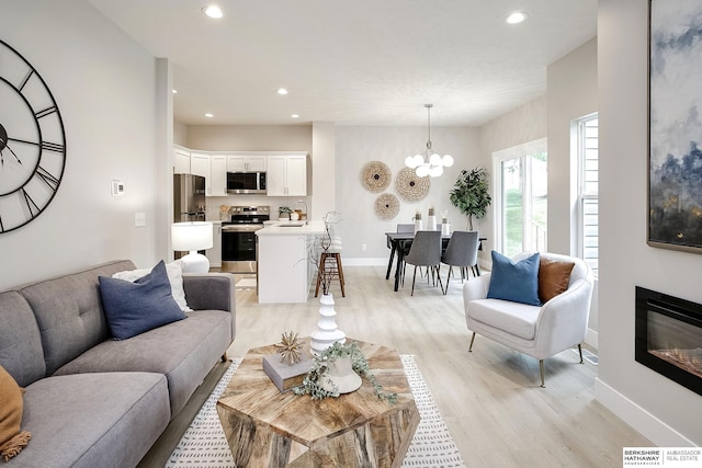 5445 S 51st St, Omaha, NE 68117 - living area featuring light wood-style flooring, recessed lighting, a chandelier, baseboards, and a glass covered fireplace