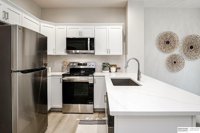 5445 S 51st St, Omaha, NE 68117 - kitchen with appliances with stainless steel finishes, a sink, a peninsula, and backsplash