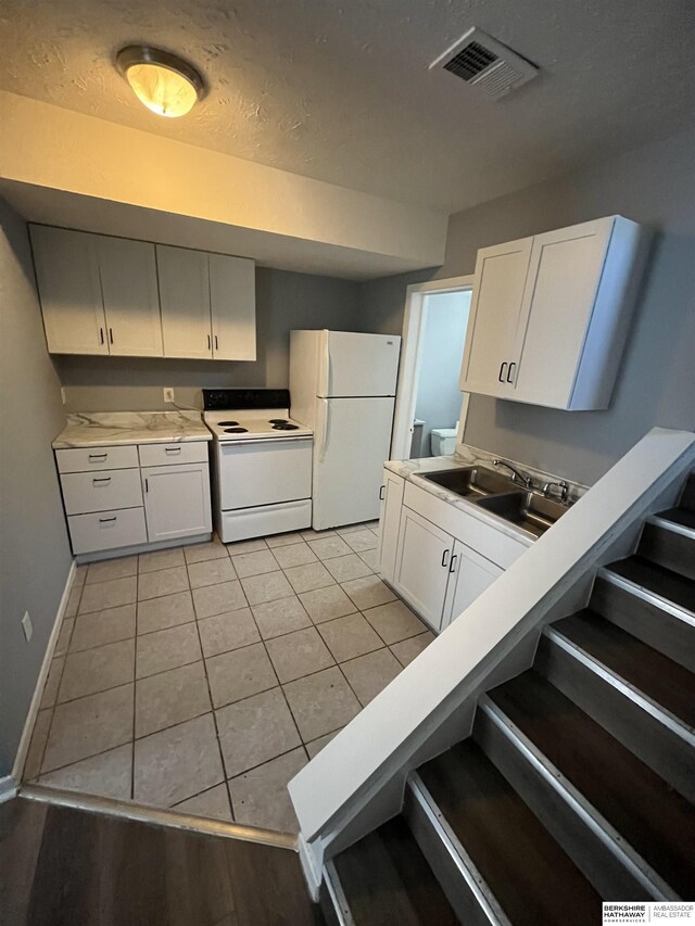 1136-1138 N D St, Fremont, NE 68025 - kitchen with white appliances, a sink, baseboards, white cabinetry, and light countertops
