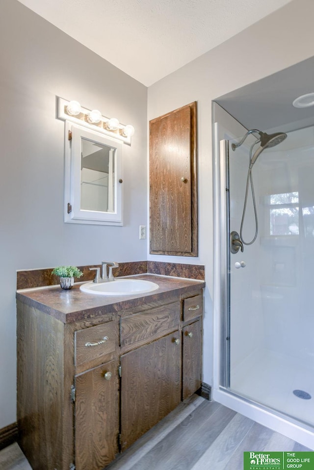 3209 Coffey Ave, Omaha, NE 68123 - full bath featuring a shower stall, vanity, and wood finished floors