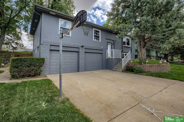 3209 Coffey Ave, Omaha, NE 68123 - raised ranch with a garage, concrete driveway, and brick siding