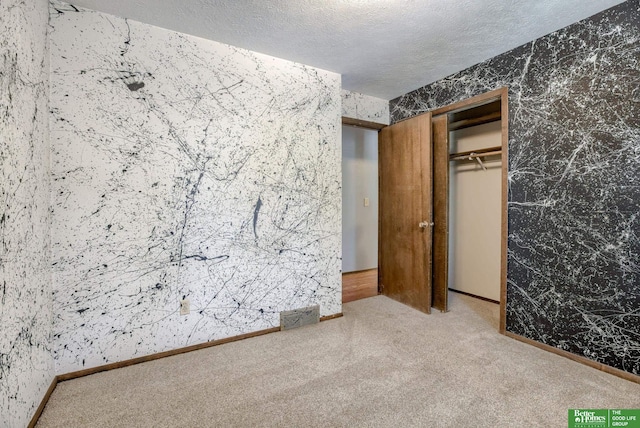 3209 Coffey Ave, Omaha, NE 68123 - unfurnished bedroom with carpet flooring, wallpapered walls, a textured ceiling, a closet, and baseboards