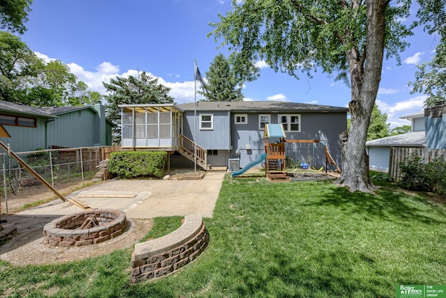 3209 Coffey Ave, Omaha, NE 68123 - back of house featuring a fire pit, a playground, a sunroom, and a patio area
