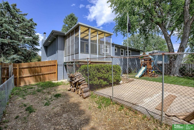 3209 Coffey Ave, Omaha, NE 68123 - back of house featuring a playground, a chimney, and a fenced backyard