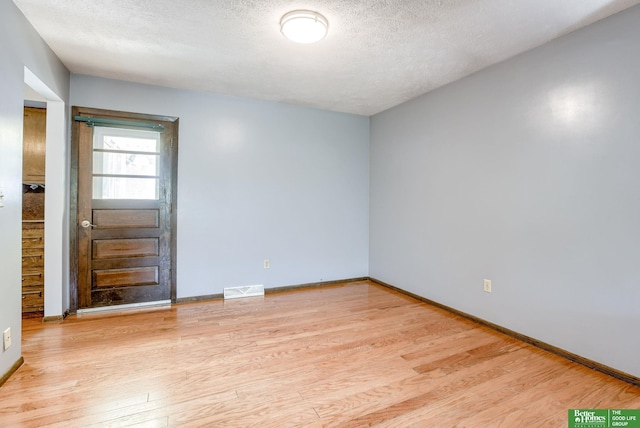 3209 Coffey Ave, Omaha, NE 68123 - unfurnished room with light wood-style flooring, baseboards, and a textured ceiling