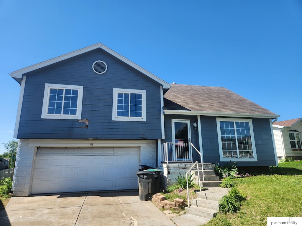 7903 Bartlett St, Omaha, NE 68122 - tri-level home featuring concrete driveway, a garage, and a shingled roof