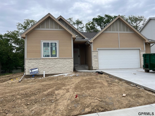 4510 Barksdale Dr, Bellevue, NE 68133 - view of front of property featuring stone siding, board and batten siding, a garage, and concrete driveway