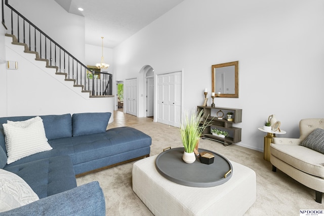 910 W Centennial Rd, Papillion, NE 68046 - carpeted living room featuring stairs, a high ceiling, a chandelier, arched walkways, and baseboards