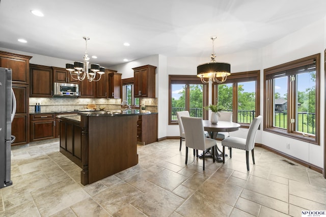 910 W Centennial Rd, Papillion, NE 68046 - kitchen featuring a chandelier, appliances with stainless steel finishes, plenty of natural light, dark countertops, and recessed lighting