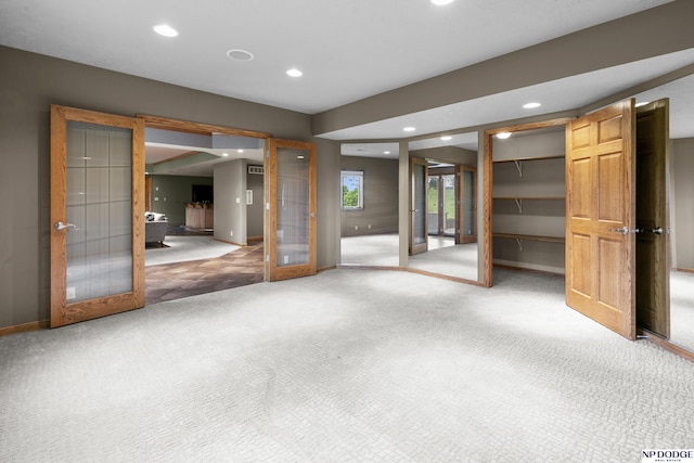 910 W Centennial Rd, Papillion, NE 68046 - unfurnished bedroom featuring french doors, recessed lighting, light colored carpet, baseboards, and a walk in closet