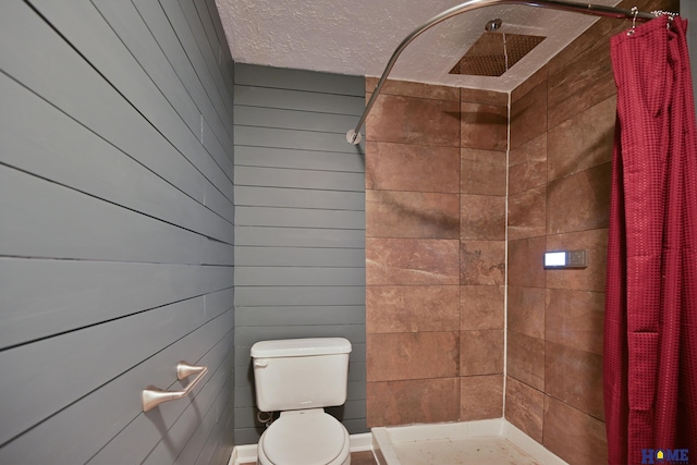 7348 N 19th St, Lincoln, NE 68521 - bathroom with tiled shower, toilet, wooden walls, and a textured ceiling
