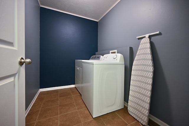 7348 N 19th St, Lincoln, NE 68521 - washroom featuring washing machine and clothes dryer, ornamental molding, dark tile patterned floors, baseboards, and a textured ceiling
