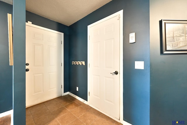7348 N 19th St, Lincoln, NE 68521 - foyer entrance featuring tile patterned flooring, baseboards, and a textured ceiling