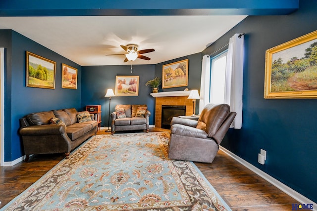 7348 N 19th St, Lincoln, NE 68521 - living area featuring dark wood-style floors, a ceiling fan, baseboards, and a tiled fireplace