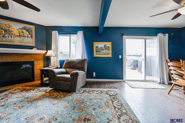 7348 N 19th St, Lincoln, NE 68521 - living area with a ceiling fan, hardwood / wood-style flooring, beam ceiling, baseboards, and a glass covered fireplace