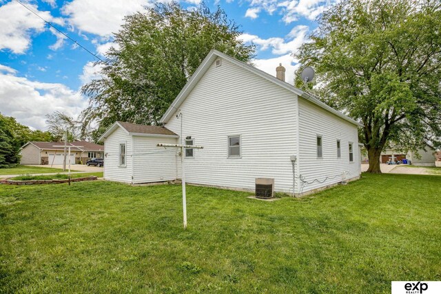 101 Station St, Shelby, IA 51570 - view of side of home with a lawn, cooling unit, and a chimney