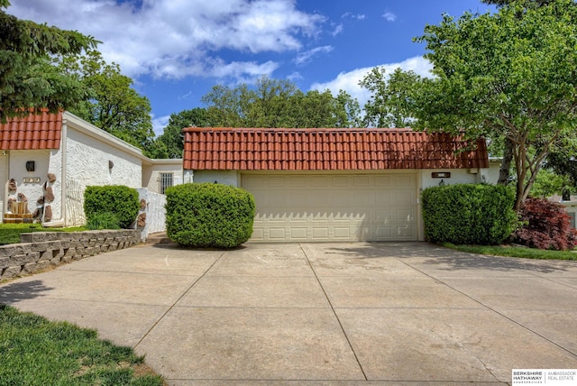 1905 S 116th St, Omaha, NE 68144 - view of front of home featuring stucco siding, driveway, a tiled roof, and a garage