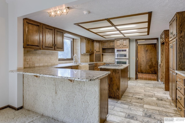1905 S 116th St, Omaha, NE 68144 - kitchen with tasteful backsplash, a kitchen island, appliances with stainless steel finishes, a peninsula, and a sink