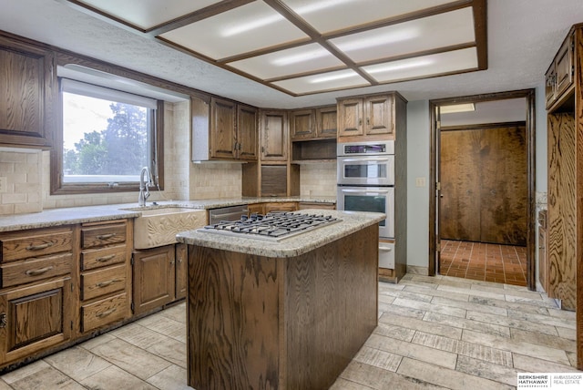 1905 S 116th St, Omaha, NE 68144 - kitchen featuring a kitchen island, a sink, decorative backsplash, and stainless steel appliances
