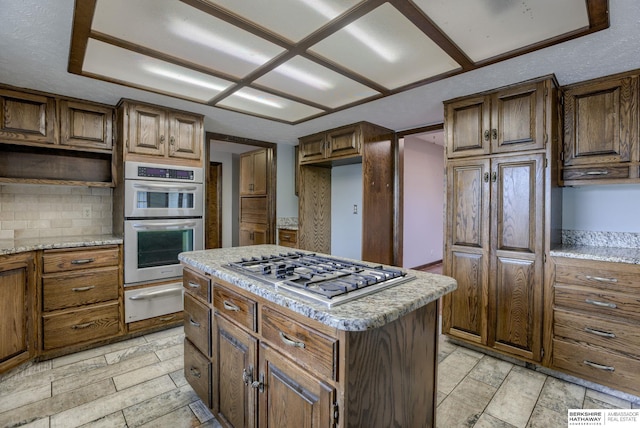 1905 S 116th St, Omaha, NE 68144 - kitchen featuring a warming drawer, appliances with stainless steel finishes, open shelves, a kitchen island, and decorative backsplash