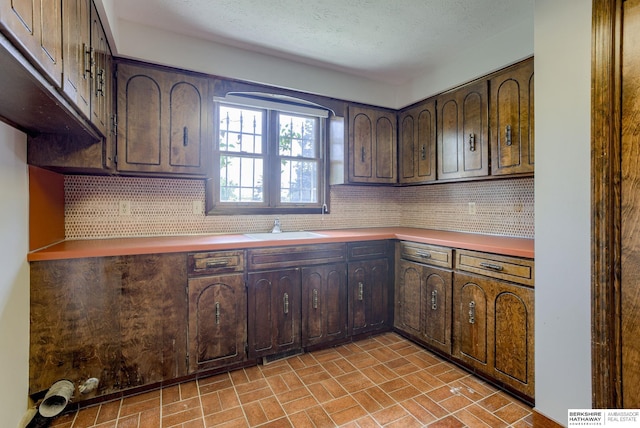 1905 S 116th St, Omaha, NE 68144 - kitchen with a sink, backsplash, brick patterned floors, and dark brown cabinetry