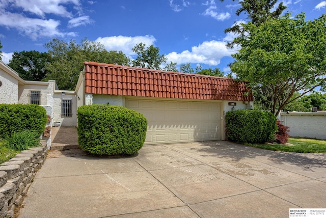 1905 S 116th St, Omaha, NE 68144 - front facade with a tile roof, driveway, stucco siding, and an attached garage