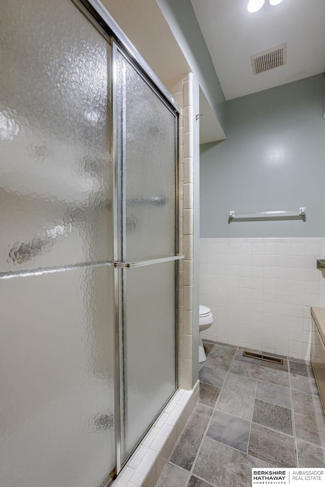 1905 S 116th St, Omaha, NE 68144 - full bath featuring tile walls, a stall shower, toilet, vanity, and a wainscoted wall