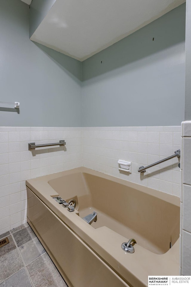 1905 S 116th St, Omaha, NE 68144 - bathroom featuring tile walls, a garden tub, and wainscoting