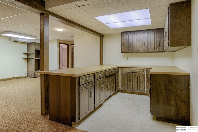 1905 S 116th St, Omaha, NE 68144 - kitchen with a paneled ceiling, a peninsula, light countertops, and dark brown cabinetry
