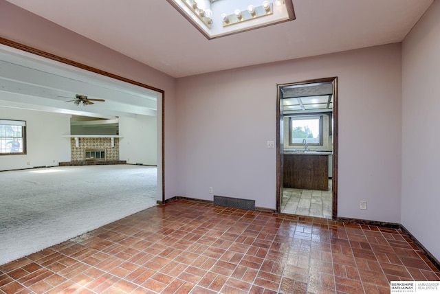 1905 S 116th St, Omaha, NE 68144 - empty room featuring plenty of natural light, brick patterned floors, ceiling fan, and baseboards