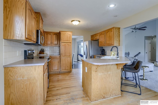 705 Ruby Rd, Papillion, NE 68133 - kitchen featuring appliances with stainless steel finishes, a peninsula, a sink, and light wood-type flooring