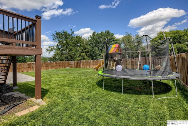 705 Ruby Rd, Papillion, NE 68133 - view of yard with a trampoline, stairs, a playground, and a wooden deck