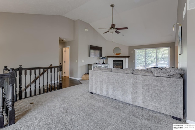 705 Ruby Rd, Papillion, NE 68133 - carpeted living room with ceiling fan, a glass covered fireplace, baseboards, and high vaulted ceiling