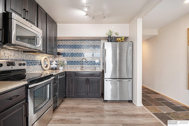 3000 Farnam St Unit 6H, Omaha, NE 68131 - kitchen with appliances with stainless steel finishes, a sink, decorative backsplash, and light countertops