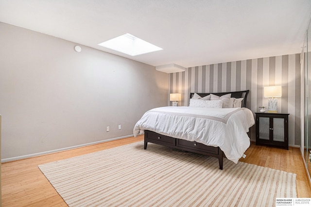 3000 Farnam St Unit 6H, Omaha, NE 68131 - bedroom featuring a skylight, wood finished floors, baseboards, and wallpapered walls