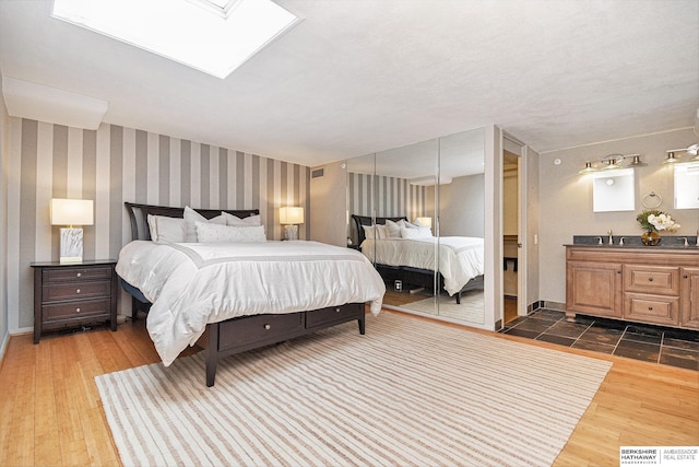 3000 Farnam St Unit 6H, Omaha, NE 68131 - bedroom featuring a sink, dark wood-style floors, a skylight, and baseboards