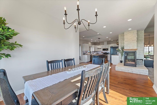 27896 Chestnut Rd, Treynor, IA 51575 - dining area featuring a chandelier, light wood finished floors, a stone fireplace, and recessed lighting