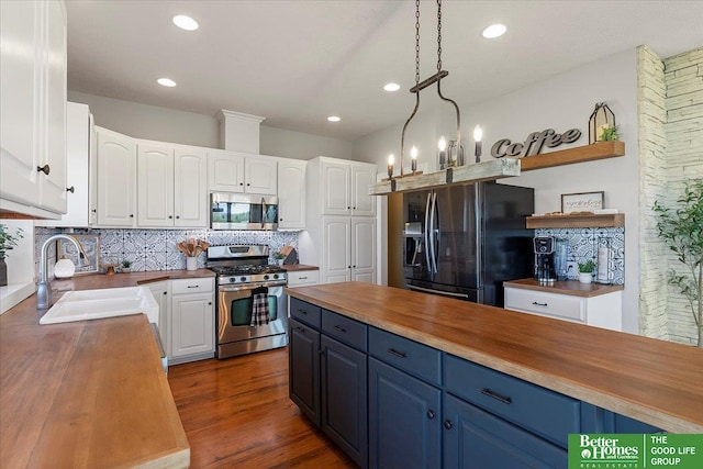 27896 Chestnut Rd, Treynor, IA 51575 - kitchen featuring stainless steel appliances, wooden counters, a sink, open shelves, and blue cabinetry