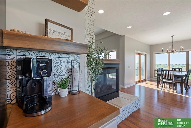 27896 Chestnut Rd, Treynor, IA 51575 - dining area featuring wood finished floors, a chandelier, a multi sided fireplace, recessed lighting, and baseboards