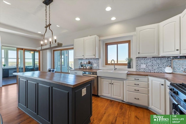 27896 Chestnut Rd, Treynor, IA 51575 - kitchen with butcher block counters, a sink, stainless steel appliances, a kitchen island, and white cabinetry