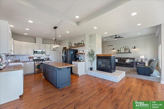 27896 Chestnut Rd, Treynor, IA 51575 - kitchen with stainless steel appliances, a sink, white cabinetry, a kitchen island, and recessed lighting