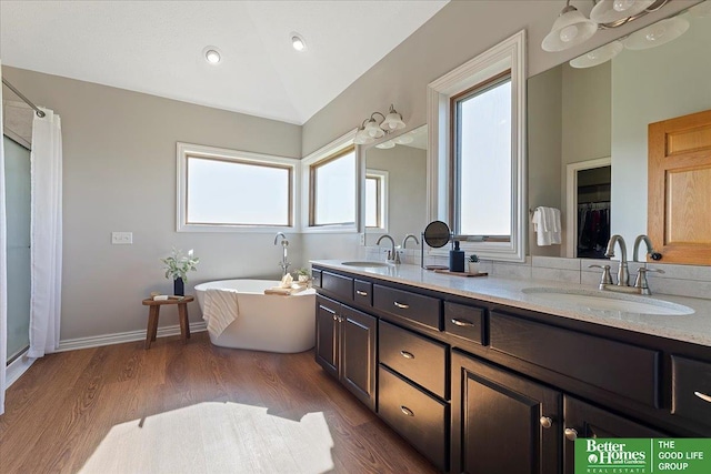 27896 Chestnut Rd, Treynor, IA 51575 - bathroom featuring double vanity, a freestanding bath, wood finished floors, and curtained shower