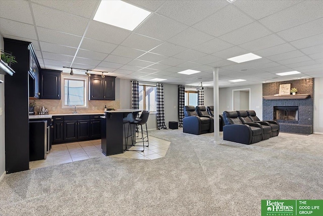 27896 Chestnut Rd, Treynor, IA 51575 - kitchen featuring a breakfast bar area, light countertops, light colored carpet, a fireplace, and open floor plan