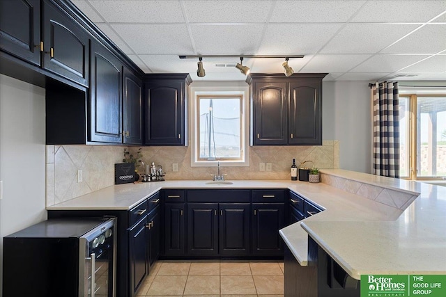 27896 Chestnut Rd, Treynor, IA 51575 - kitchen with a peninsula, track lighting, a sink, light countertops, and beverage cooler