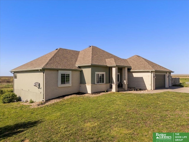 27896 Chestnut Rd, Treynor, IA 51575 - view of front of property with driveway, a garage, a front yard, brick siding, and a shingled roof