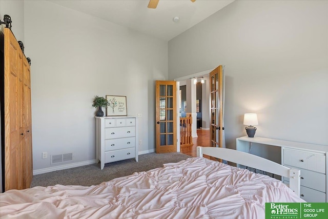 27896 Chestnut Rd, Treynor, IA 51575 - carpeted bedroom featuring french doors, a towering ceiling, a barn door, and baseboards
